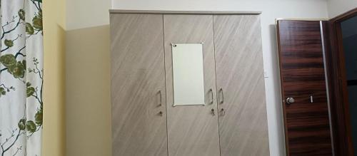 a wooden cabinet with a mirror in a room at Happy Ladies PG in Kammasandra