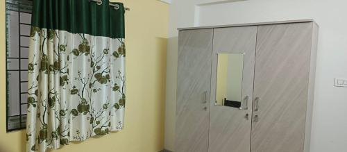 a bathroom with a shower curtain and a door at Happy Ladies PG in Kammasandra