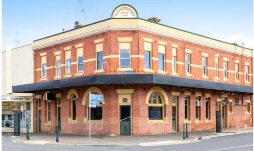 a red brick building on the corner of a street at The Vine & Lamb in Saint Arnaud