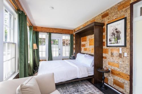 a bedroom with a bed and a brick wall at The Legacy Inn in Luray