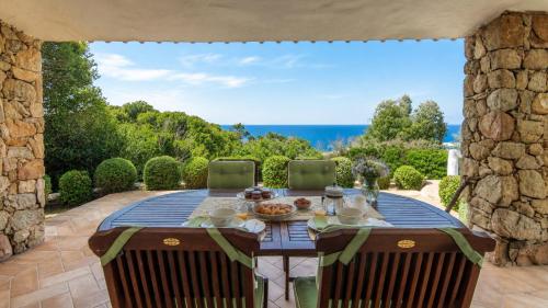 a table on a patio with a view of the ocean at Villa Turchese - Key to Villas in Costa Paradiso