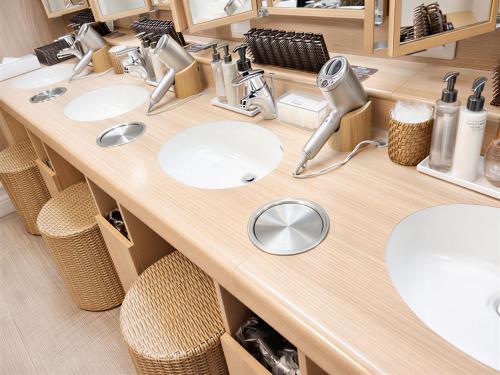 a bathroom with two sinks and two mirrors at Dormy Inn Express Mikawaanjo in Anjomachi