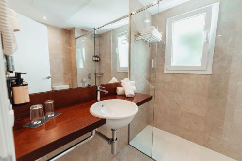 a bathroom with a sink and a glass shower at Sagitario Princesa Playa in Son Xoriguer
