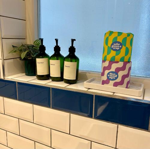 three bottles of wine sitting on a window sill at Garden Apartment by the Pier in Portsmouth