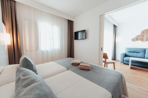 a bedroom with a bed and a blue couch at Sagitario Princesa Playa in Son Xoriguer