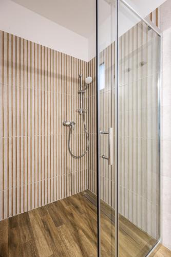 a shower with a glass door in a bathroom at DANUBike in Dobrohošť