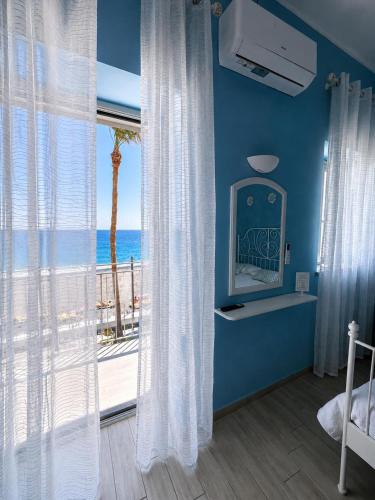 a bedroom with a window with a view of the ocean at Ciao Ciao Rooms in Letojanni