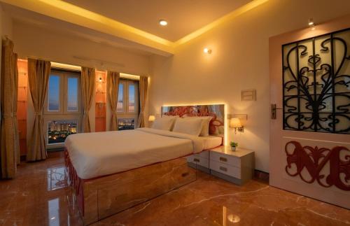 a large bedroom with a large bed and windows at The Collectors Loft in Jaipur