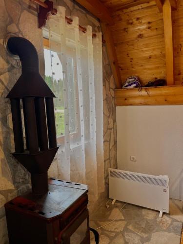 a room with a stove and a window at Vikendica Anja in Žabljak