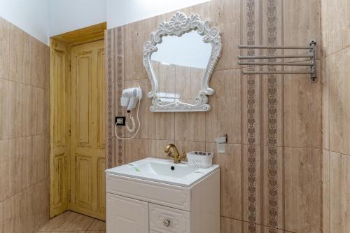 a bathroom with a sink and a mirror on the wall at Hotel Boutique Casa Vermont in Bucharest