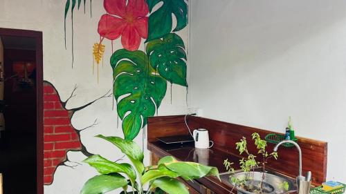 a bathroom with a sink with a flower on the wall at C U Hostel in Trincomalee