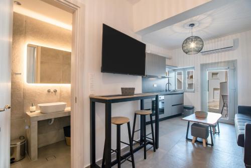 eine Küche und ein Wohnzimmer mit einer Bar in einem Zimmer in der Unterkunft Næxon in Vívlos