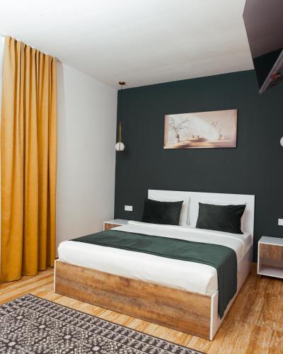 a bedroom with a large bed with a black wall at GetAp Resort Arzni in Arzni