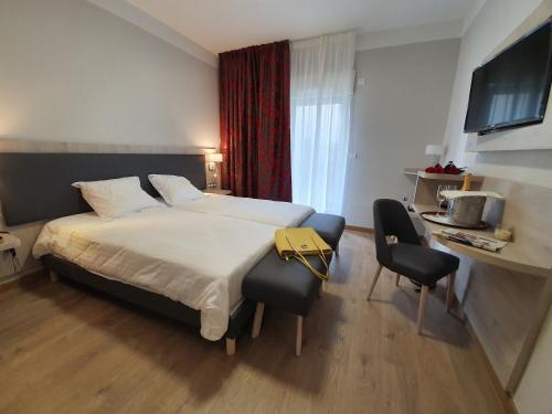 a hotel room with a large bed and a desk at Berg'hotel in Socx