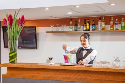 a woman sitting at a bar with a drink at San Agustin Riviera in Lima