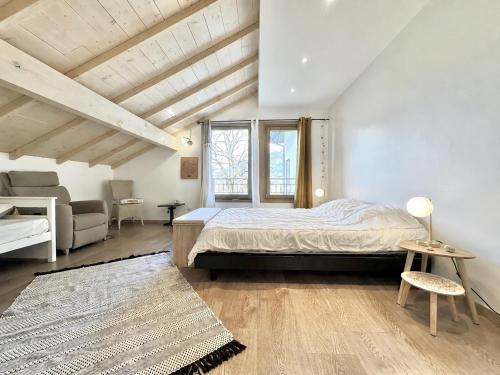 a bedroom with a bed and a large window at La Bergerie de Losse in Traize
