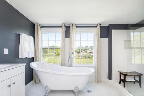 a white bath tub in a bathroom with a window at The Legacy Inn in Luray