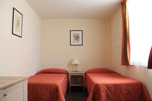 a room with two beds and a table and a window at Il Parco Sul Mare Resort & SPA in Tortoreto Lido