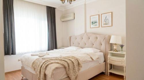 a white bedroom with a bed with a blanket on it at Spacious Villa with Sea and Mountain View in Kemer