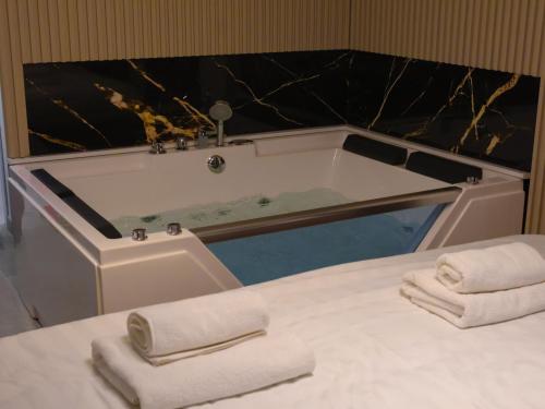 a bathroom with a tub with towels on a table at Rentalica in Belgrade