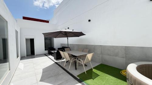 a dining room with a table and an umbrella at The white house in Vecindario