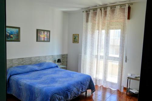 a bedroom with a blue bed and a window at Cassiodoro Rooms Affittacamere in Catanzaro