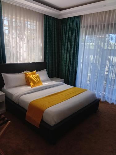 a bedroom with a bed with a yellow blanket at SixPoint Victoria in Kisumu