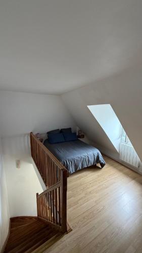 a bedroom with a bed and a staircase in a attic at Hyper centre ville de Reims avec parking in Reims
