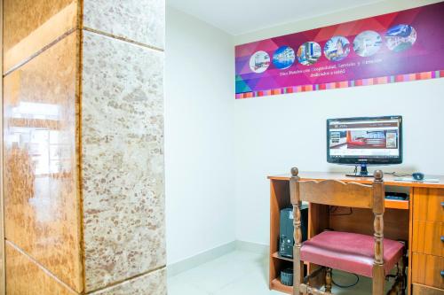 a room with a desk with a computer and a wall at San Agustin Riviera in Lima