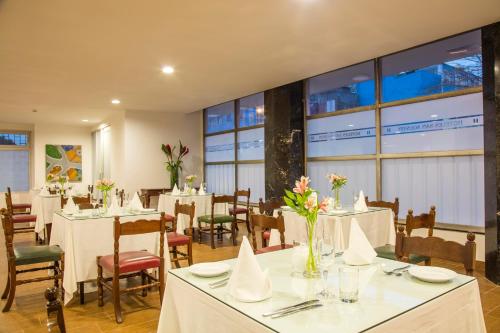 restauracja z białymi stołami, krzesłami i oknami w obiekcie San Agustin Riviera w mieście Lima