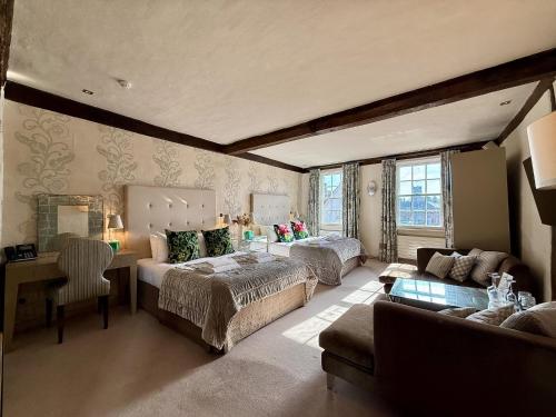 a large room with two beds and a couch at The Great House Lavenham Hotel & Restaurant in Lavenham