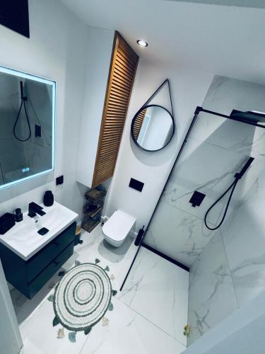 a bathroom with a sink and a shower and a toilet at View Apartments Gorlice in Gorlice