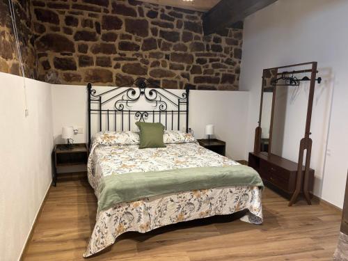 a bedroom with a bed and a brick wall at Casa Dulcinea en Brañosera Montaña Palentina. in Brañosera