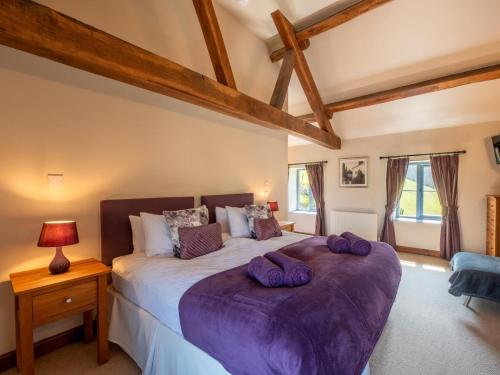 a bedroom with a large bed with purple sheets at 5 Bed in Llangammarch Wells oc-bn162 in Garth