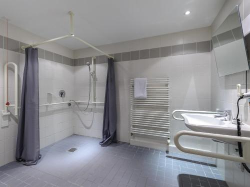 a bathroom with a shower and a sink at ibis Hotel München Messe in Feldkirchen