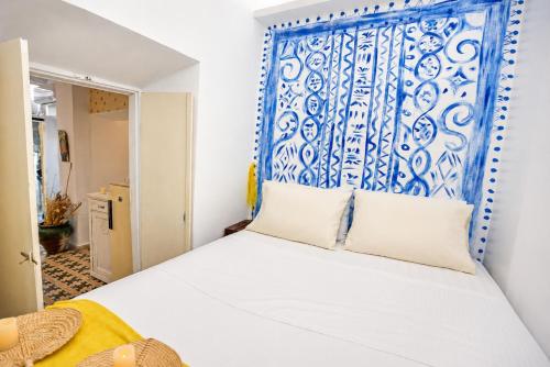 a bedroom with a bed with a blue and white headboard at Danielle 626 House Ano Syros in Ano Syros