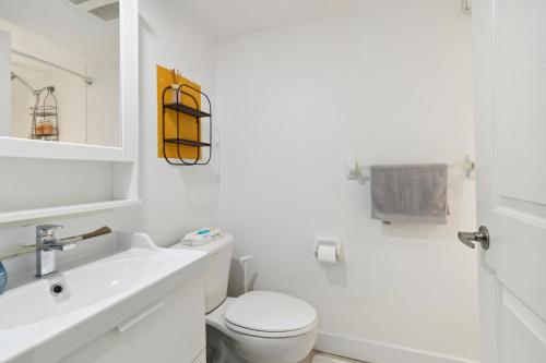 a white bathroom with a toilet and a sink at Great Located Studio perfect for 2 with parking in Toronto