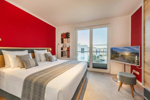 a bedroom with a large bed and a red wall at Ein Traum am Haff in Zirchow