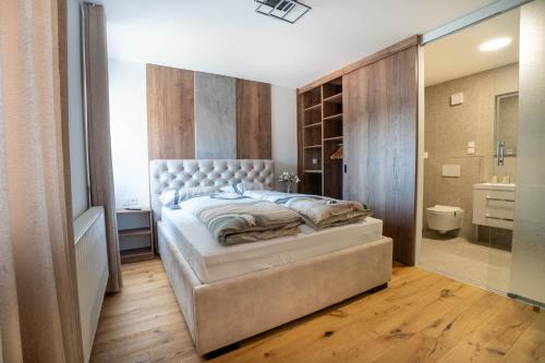 a bedroom with a large bed and a bathroom at Apartma na Grad in Ptuj
