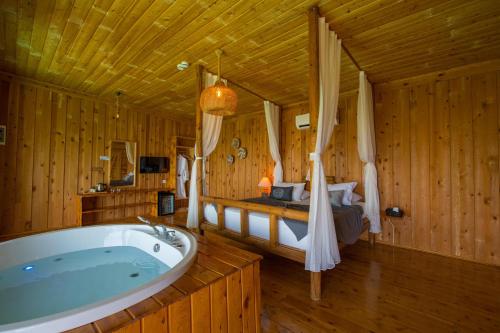 a large bathroom with a tub and a bed at Heaven Resort Faralya in Fethiye