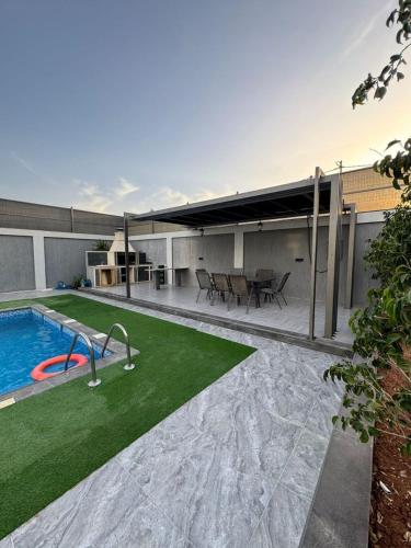a house with a swimming pool and a patio at aqua chalets شاليهات أكوا in Al Rama