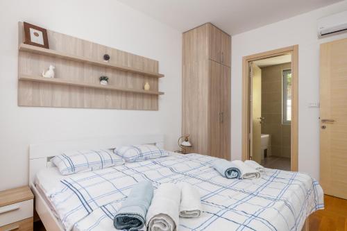 a bedroom with a bed with towels on it at Lavender Bay Apartment C21 in Donji Morinj
