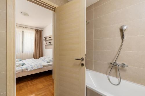 a bathroom with a shower and a bath tub at Lavender Bay Apartment C21 in Donji Morinj