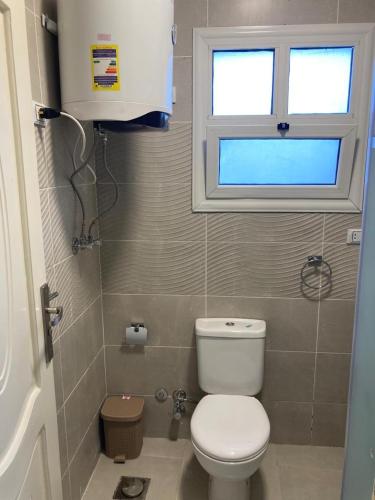 a small bathroom with a toilet and a window at High quality apartment Madinty in Cairo
