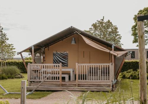 a yurt with a table and chairs in a yard at Safaritenten Betuwe in Kesteren