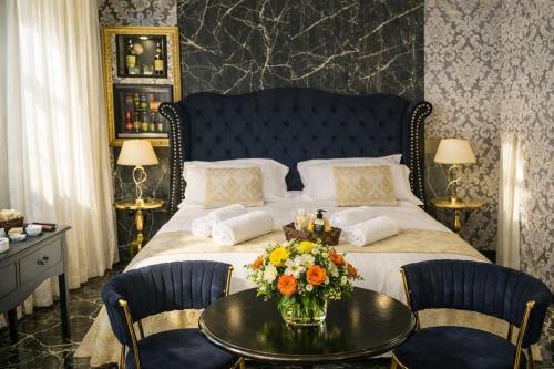 a bedroom with a large bed with a table with flowers on it at Barberini Dream in Rome
