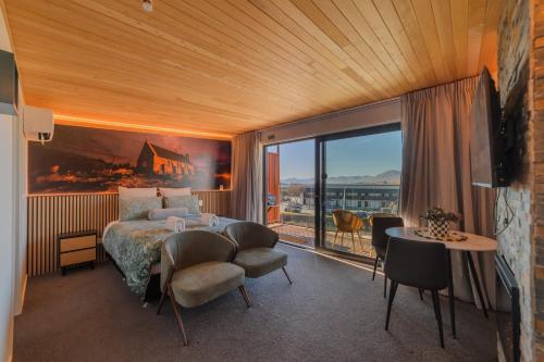 a bedroom with a bed and a large window at Starlight Escape - Ohana in Lake Tekapo