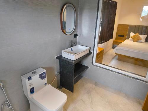 a bathroom with a sink and a toilet and a mirror at Berry Fresh Stays Mahabaleshwar With Pool in Mahabaleshwar