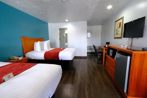 a hotel room with two beds and a flat screen tv at M Star Hotel Searcy in Searcy