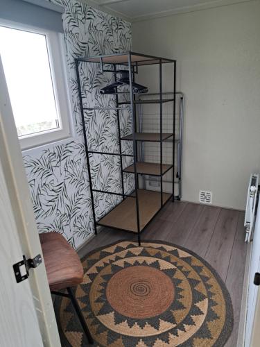 a room with a rug and a shelf with shoes at Camping de Zandhorst, Chalet Madera in Wouterswoude